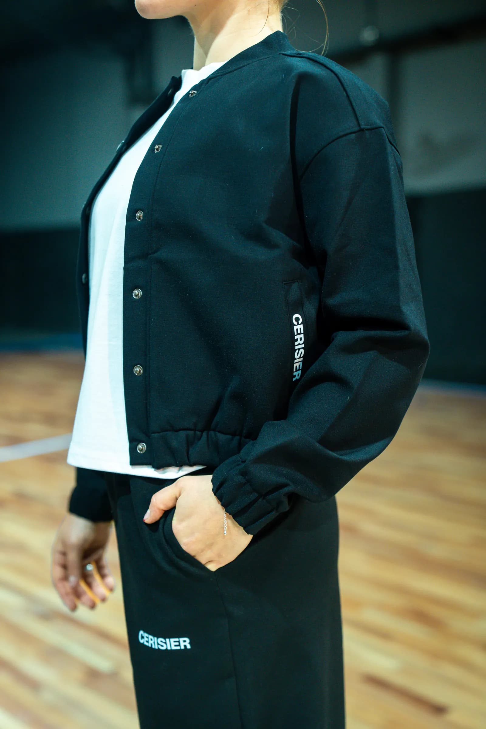 Campera negra y jogging gris, de la cintura hacia abajo